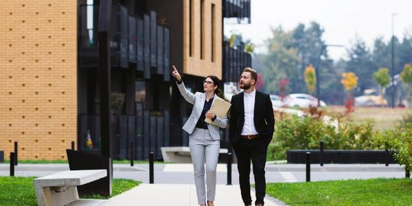 Two business professionals walking outside a commercial building